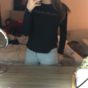 Calvin Klein tröja - Säljer en stilren svart långärmad tröja med textdetalj på bröstet. Perfekt för både vardag och fest. Tröjan har en normal passform och är superbekväm. Passar till allt från jeans till kjol!