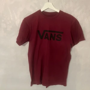 Vinröd t-shirt från Vans - Säljer en snygg vinröd t-shirt från Vans med deras klassiska logga i svart på bröstet. Mycket bra skick.