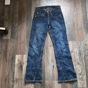 Levi's jeans i blå denim - Säljer ett par klassiska Levi's jeans i blå denim. De har en bootcut-stil och är i bra skick. Perfekta för både vardag och fest! 🕺👖