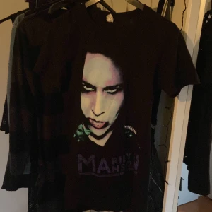 Svart Marilyn Manson t-shirt - Säljer en svart t-shirt med tryck av Marilyn Manson. Materialet känns mjukt och bekvämtstår ingen storlek men skulle säga att den är typ S💕🫶🏻