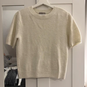 Vit stickad tröja - Säljer en superfin vit stickad tröja i mycket bra skick. Den har korta ärmar och en rund halsringning. Perfekt för både vår och sommar, och den är riktigt mysig att ha på sig. Passar till både jeans och kjol!