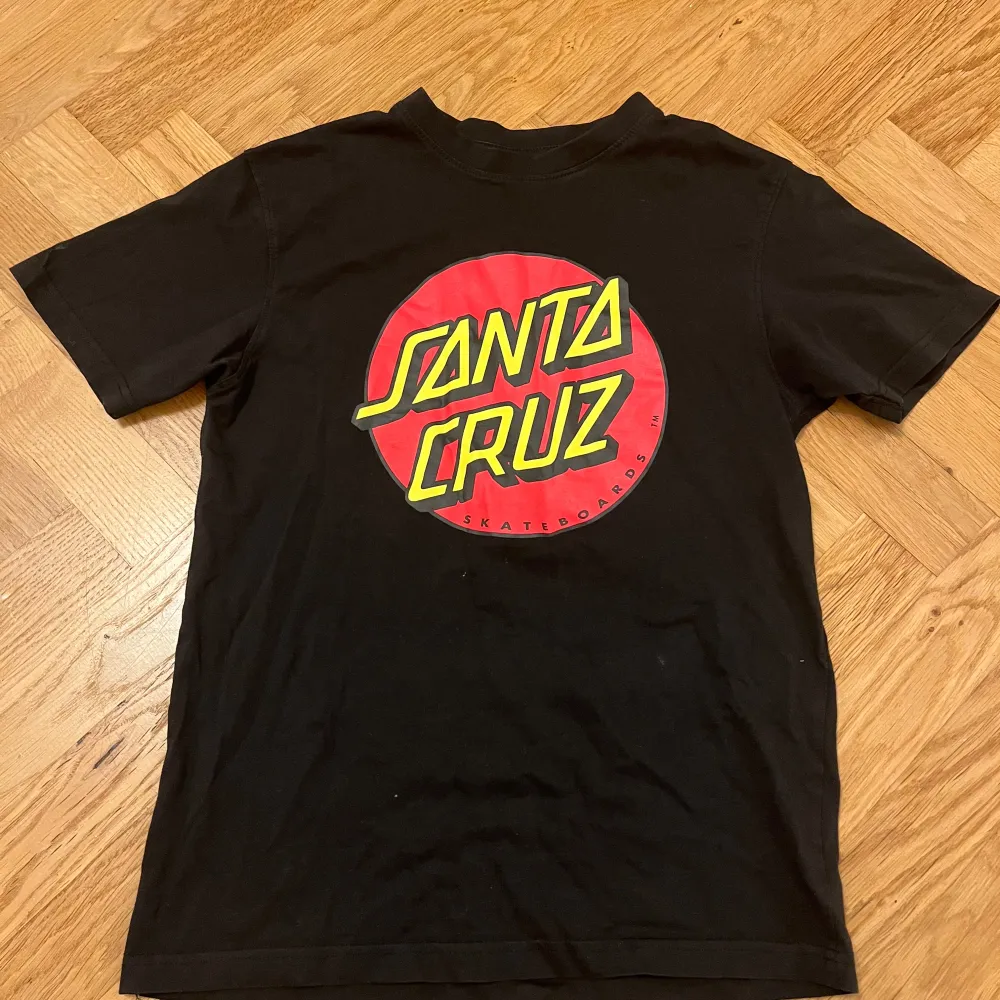 Säljer en svart t-shirt från Santa Cruz i bra skick. Det står att den är i S men är för liten för mig så antagligen Xs. Köpt på Sellpy. Jättebra för skating. Pris kan diskuteras ‼️. T-shirts.