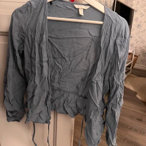 Blå omlottblus - Snygg blå omlottblus med knytband i midjan. 