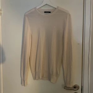Beige tröja från J.Lindeberg - Säljer en stilren beige tröja från J.Lindeberg i storlek S. Tröjan är långärmad och har en diskret broderad logga på bröstet. Perfekt för både vardag och fest. Materialet känns mjukt och bekvämt. Passar bra till både jeans och chinos!