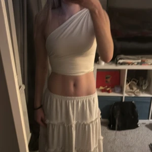 Vit oneshoulder topp - Snygg vit oneshoulder topp som är perfekt för sommardagar. Den har en tight passform och är tillverkad i ett mjukt material som sitter skönt mot huden. Aldrig använd, skriv för mer information💕