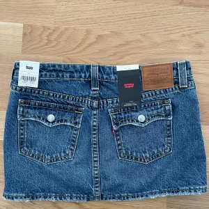 Mini jeanskjol från Levi’s - Supersnygg, trendig mini jeanskjol från Levi’s, ”One in a Million, blue denim”. Aldrig använd med prislapparna kvar. Säljes pga för liten storlek!💕