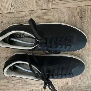 Säljer ett par stilrena svarta sneakers från Zara i storlek 42. Skorna är i nyskick, endast använt en gång under studenten.