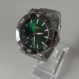 Oris Aquis Date - • Modell: Oris Aquis Date • Storlek: 43,5 mm • Referens: 01 733 7730 4157 • År: 2018 • Skick: Mycket Bra • Medföljer: Fullset med värdhet/äkthets intyg samt extra mörkbrunt läderband från Oris