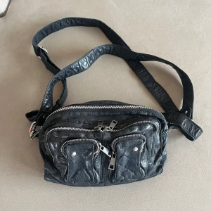 Nunoo väska - Nypris 1799kr, använd med i fint skick. Går att bära väskan på fler sätt, ingår ett lång band. 