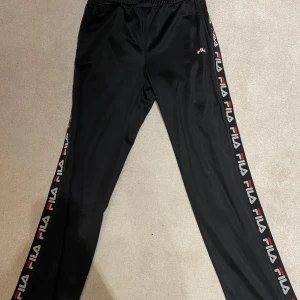 Fila byxor - Säljer Fila tygbyxor med märkning på sidorna, längs med vardera ben.  - Storlek XS petite (för kortare ben, är själv 158cm) - innerben 74cm ytterben 92cm - Använda fåtal gånger, mycket bra skick  Skicka PM vid frågor/köp🫶