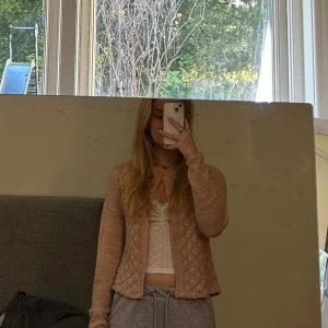 Ljusrosa stickad kofta från Pomp de Lux - Säljer en superfin ljustos stickad kofta från Pomp de Lux. Den har ett mönster och långa ärmar.Koftan är i bra skick. Passar som S 