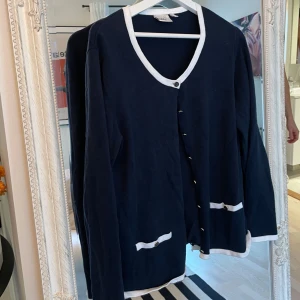 Marinblå kofta med vita detaljer - Säljer en kofta med vita detaljer. Perfekt för både vardag och lite finare tillfällen. Supermjuk och bekväm att ha på sig! I storlek XL från isolde men sitter som en ca oversized M, jag brukar oftast ha S som referens. Rich mom vibe på denna