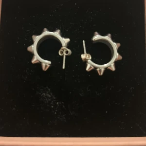 Silvriga örhängen med nitar från Edblad, största man kan hitta på hemsidan💓💓💓 - Snygga och trendiga silvriga örhängen från Edblad med coola nitar runt om. Perfekta för att ge din outfit en edgy touch. De är i nytt skick och kommer i originalförpackning. Passar både till vardags och fest! Kostar 400 på hemsidan