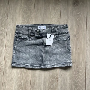 Motel rocks mini denim skirt  - Säljer en supercool grå jeanskjol från Motel Rock i low rise modell. Den har en klassisk femficksdesign med knapp och dragkedja framtill. Perfekt för en avslappnad look eller att styla upp för fest! 🖤(inte använd då den var för liten) 