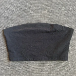 Svart tubtopp från 157 - Säljer en stilren svart tubtopp från 157 i storlek M. Perfekt för sommardagar eller som en basplagg under en jacka. Toppen är i bra skick och har en enkel design som passar till det mesta. Ett måste i garderoben