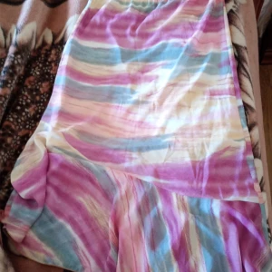 Kjol mönstrad med resår o volang stl L/xl - Fin mönstrad kjol med resår i midjan och volang samt kort innekjol.storlek L/XL. Material Polyester och Silke 