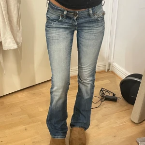 Blå bootcut jeans - Säljer ett par snygga blå bootcut jeans i bra skick. De är lågmidjade och har en superfin tvätt. Midjemått är ca 38cm. Jag är 167 på bild som referens 💕