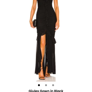 Klänning - En svart klänning med bandue. Klänningen är i nyskick, otroligt fin och en liten slits i kjolen. Den är perfekt för en festlig tillställning. Nypris 3500kr köpt på REVOLVE men från märket majorelle!