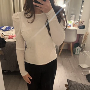 Vit långärmad topp med öppen rygg - Säljer en jättefin vit topp med långa ärmar och en snygg öppen ryggdetalj. Perfekt för både vardag och fest! Toppen har en tight passform och är superbekväm. Den är i nyskick och aldrig använd. Du kan själv justera hur mycket ”öppen” du vill att ryggen ska vara 💗