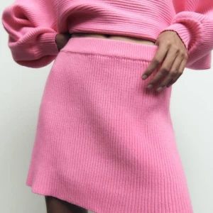 Rosa ribbad kjol och långärmad tröja, matchande set från Zara  - Superfin matchande rosa ribbad set från Zara i storlek XS. Perfekt för både vardag och fest! Den stickade kjolen och tröjan är i nytt skick och har en härlig stretchig passform. Ett måste i garderoben för vintern!