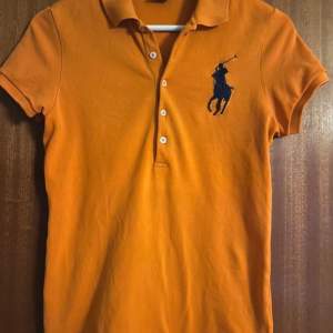 Orange pikétröja från Ralph Lauren i storlek S. Passar xs-m då den är lite stretchig. Mycket bra skick! 