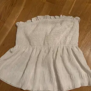 En vit off shoulder tubtopp i storlek s men väldigt stretchigt material och passar mig som brukar ha m.