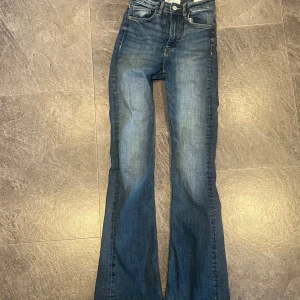 Blå bootcut jeans från Zara - Säljer ett par snygga blå bootcut jeans från Zara i storlek EUR 34. De har en klassisk femficksdesign och är i mycket bra skick. Perfekta för både vardag och fest! 🕺