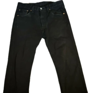 Levis 501 - Säljer ett par klassiska svarta jeans från Levi's i mycket bra skick. De har en straight passform med mycket starch kvar i jeansen.