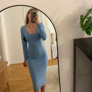 Ljusblå ribbad klänning från NLY Trend - Säljer en ljusblå klänning från Nelly i storlek XS. Den är ribbad, långärmad och har en v-ringad hals. Köptes förra året men är aldrig använd endast provad.  Prislappar hänger kvar! ☀️