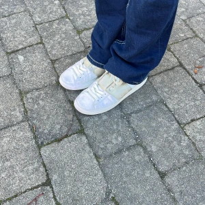 Vita sneakers från Valentino - Säljer ett par vita sneakers från Valentino i bra skick. De har en klassisk design med snörning och är perfekta för vardagsbruk. Skorna är bekväma och stilrena, vilket gör dem lätta att matcha med olika outfits. Perfekta för både vår och sommar och vinter då de är höga!