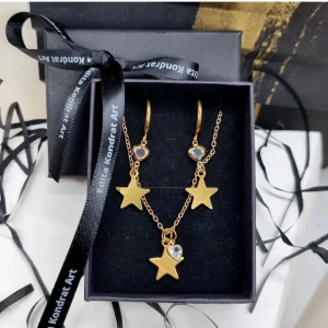 Guldstjärna smyckeset med hjärtdetaljer - Snyggt smyckeset från Eldita Kondrat Art med guldstjärnor.✨Detta charmiga smycken är en perfekt julklapp till dig själv eller någon nära. Kedjelängd-22cm(44cm), örhängen-rostfritt stål, Längd-4,5cm