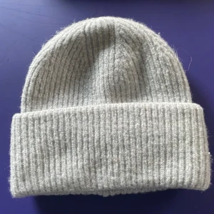Grå ribbad mössa från Gina Tricot - Säljer en supermysig grå ribbad mössa från Gina Tricot. Perfekt för kyliga dagar och håller dig varm och stilren. Den är i ett mjukt material och har en klassisk design som passar till allt. Ett måste för vintern! ❄️