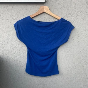 Blå topp med öppen rygg - Hejj! Säljer denna blåa öppen rygg toppen då den helt enkelt inte kommer till användning längre. Toppen är knappast använd och har därav inga defekter. Hör gärna av dig om du skulle ha några frågor!