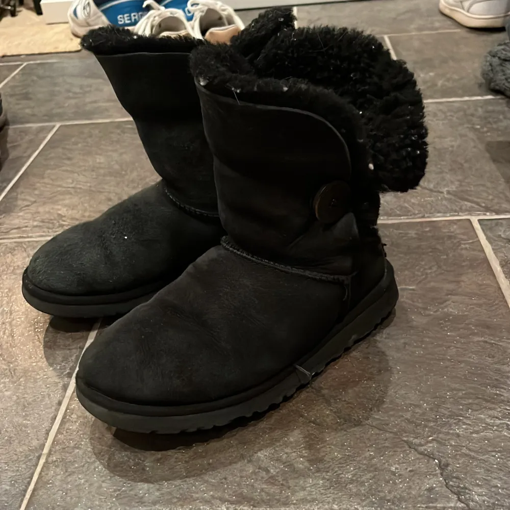 Äkta Uggs!! Superfina svarta uggs med en knapp på sidan, halvhöga❤️De är lite missfärgade men har mycket kvar att ge!! Lite slitna i sulan❤️Fint skick i övrigt🥰. Skor.