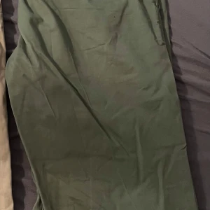 Gröna chinos från Tommy Hilfiger - Säljer ett par gröna Denton Chino Stretch byxor från Tommy Hilfiger i straight fit. De är tillverkade i TH Flex-material som är lättskött och har luktkontroll. Perfekta för både vardag och lite finare tillfällen. Superbekväma och stilrena! Endast använda vid 1 tillfällen, nyår, sedan gick min man upp i vikt och så passade dem inte längre. 