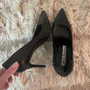 Acne-pumps i strl 40 - Snygga klassiska svarta pumps från Acne Studios, strl 40. Passar till allt - casual med ett par jeans, eller till klänning på festen. Ett måste-ha i garderoben. Använda ett tiotal gånger, mest inomhus, så i bra skick.