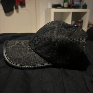 Svart keps med mönster - Snygg svart keps med diskret mönster. Perfekt för både vardag och fest. Kepsen har en klassisk passform och är gjord i ett slitstarkt material. Den är stilren och lätt att matcha med olika outfits.