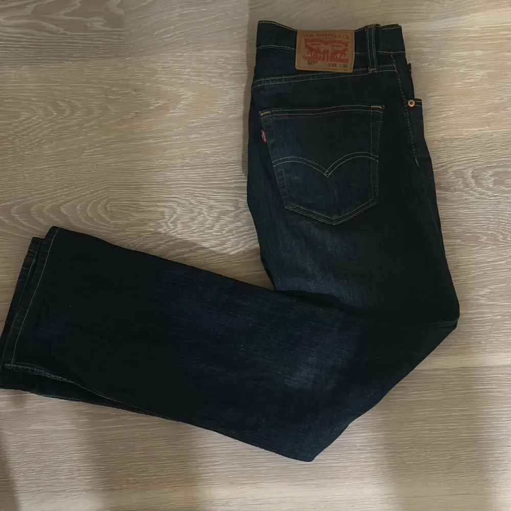 Säljer ett par snygga Levi's 527 jeans i mörkblå denim. De har en klassisk femficksdesign med dragkedja och knapp. Perfekta för både vardag och fest. Jeansen är i bra skick och redo för en ny ägare!. Jeans & Byxor.