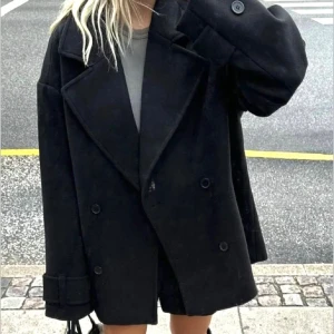 Svart oversized kappa - Säljer en supercool svart oversized kappa med knappar. Perfekt för höst och vår, den har en klassisk look med breda slag och långa ärmar. Passar perfekt till både vardag och fest. 🖤den kommer inte till användning då jag har andra jackor därav säljer jag den, slutsåld och väldigt eftertraktad (lånad bild)