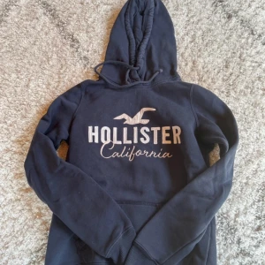 Hoodie från Hollister - Säljer en snygg och bekväm mörkblå hoodie från Hollister. Hoodien är i bra skick💗bara att fråga för fler bilder och pris kan sänkas