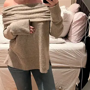 Superfin beige stickad tröja som kan bäras offshoulder för en trendig look. Den är mjuk och perfekt för kyliga dagar. Tröjan har långa ärmar och en ribbad kant vid ärmslut och nederkant. Perfekt för höst och vinter!