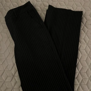 Svarta randiga kostymbyxor från Madlady - Säljer ett par snygga svarta randiga kostymbyxor från Madlady i storlek 34/regular. Fint skick, använda en gång. Nypris 649kr