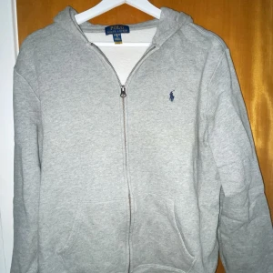 Grå hoodie från Ralph Lauren - Säljer en klassisk grå hoodie från Ralph Lauren i storlek XL. Det är en zip hoodie.