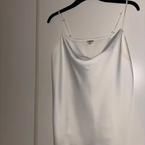 Glansig topp vit satin - Har lite missfärgning under armarna men inget som märks i verkligheten utan blixt