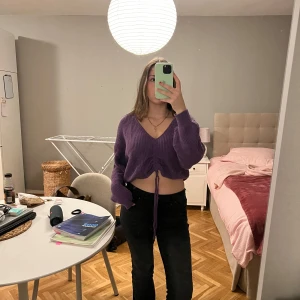 Lila stickad tröja  - Säljer en superfin lila stickad tröja från Hmed v-ringning och knytband framtill. Tröjan är i perfekt skick. Perfekt för en mysig dag eller en avslappnad kväll med vänner! 💜 Storlek M 