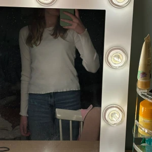 Vit ribbad tröja från Lindex - Säljer en superfin vit ribbad tröja från Lindex i storlek 158/164. Den är långärmad och perfekt för både vår, vinter och höst. Tröjan är i bra skick och passar perfekt till jeans eller kjol. Perfekt basplagg för garderoben! 🌟
