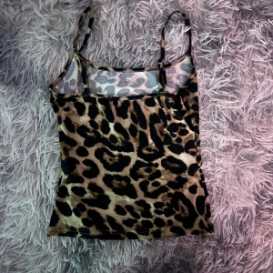 Leopardmönstrad linne - Snygg leopardmönstrad linne med justerbara axelband. Perfekt för en utekväll eller sommarfest. Materialet är mjukt och stretchigt för en bekväm passform.