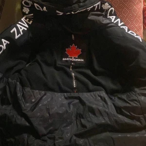 Svart pufferjacka från Zavetti Canada - Säljer en svart pufferjacka från Zavetti Canada i storlek S. Jackan är perfekt för kalla vinterdagar med sin tjocka vaddering och långa ärmar. Säljer denna jacka för jag bytt stil. Pris går att diskuteras!