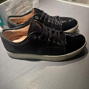 Lanvin skor - Säljer ett par snygga svarta sneakers från Lanvin i mycket bra skick. Nypris cirka 5000kr. Size 7 men sitter som 42. Köpta på mytheresa så äkta givetvis. Dustbag tillkommer. Ställ gärna frågor vid fundering!