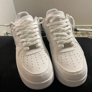 Vita Nike Air Force sneakers - Säljer ett par klassiska vita Nike Air Force sneakers i storlek herr 43. De är i nytt skick och har snygg snörning. Perfekta för både vardag och fest! 🏀👟